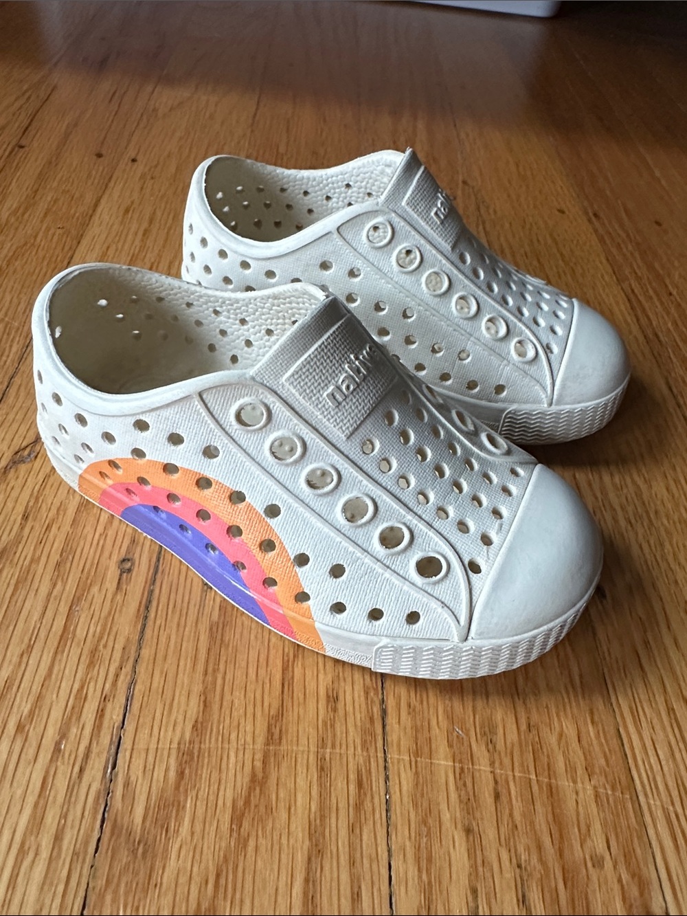 Native Kids Slip-On Sneakers in White with Rainbow Side Graphic